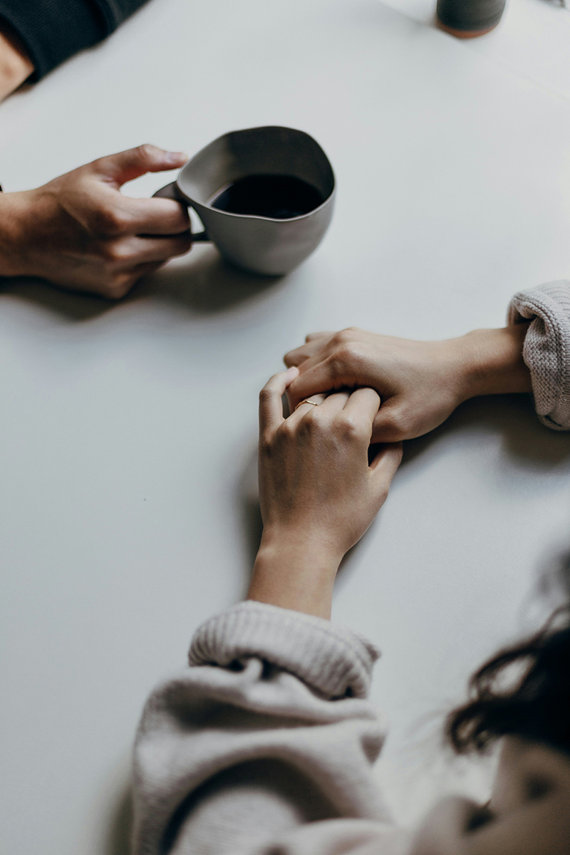 Holding hands and a coffee cup